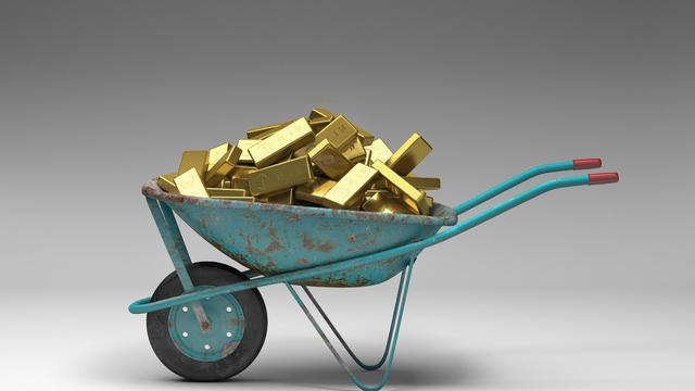 Rusty wheelbarrow full of gold bars 